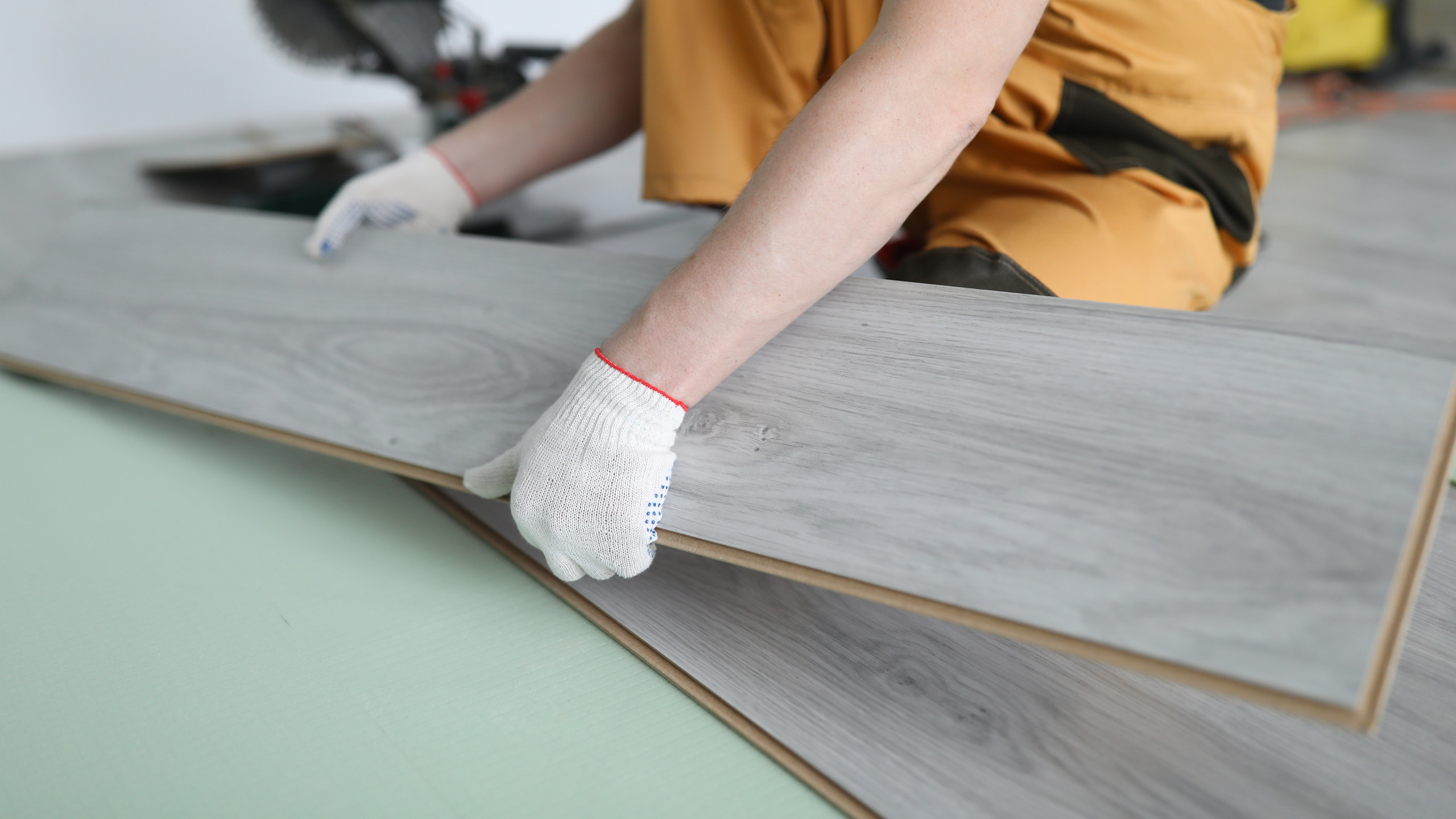 repairman-replaces-laminate-panels-floor-apartment