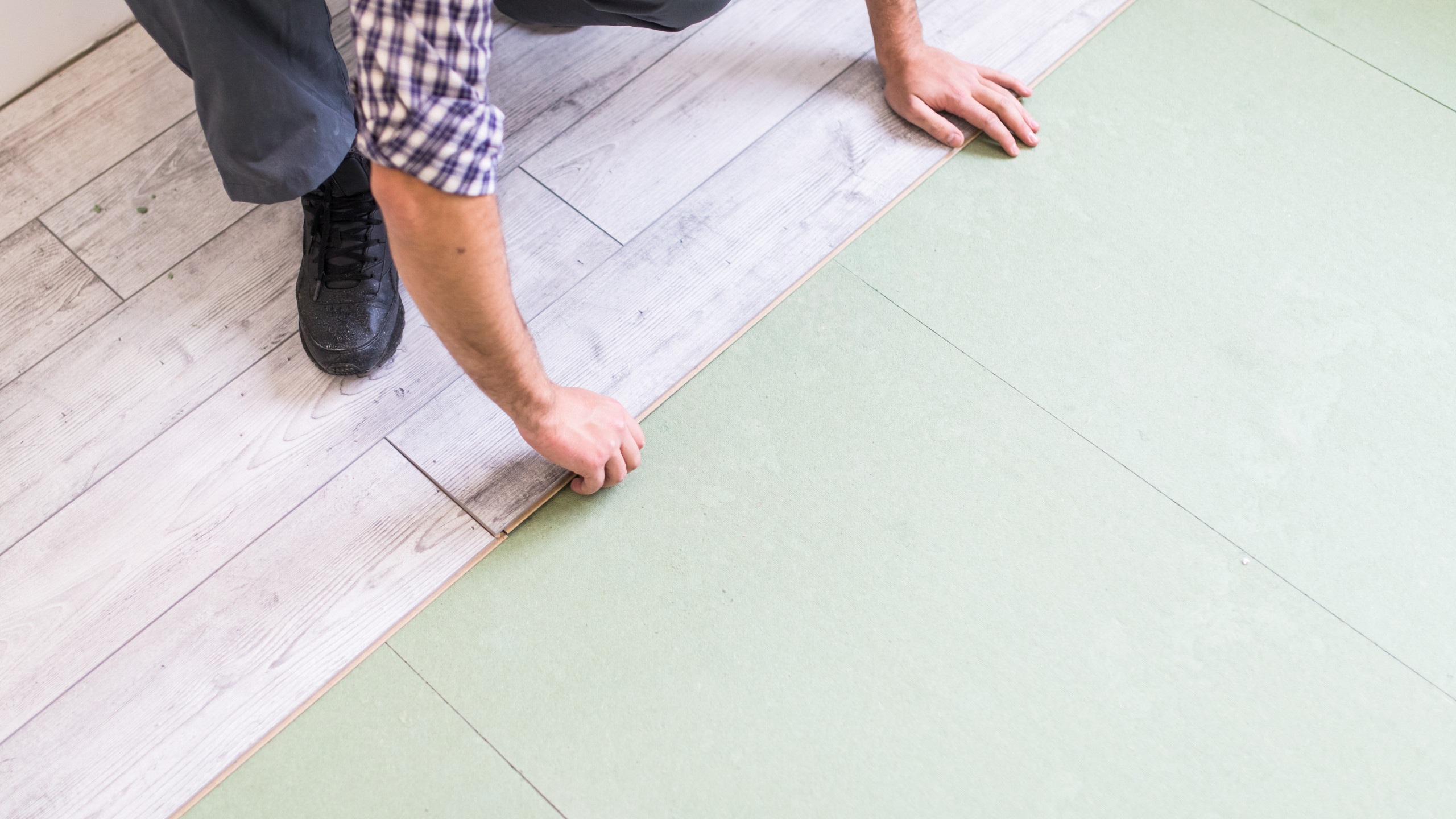 worker-processing-floor-with-bright-laminated-flooring-boards