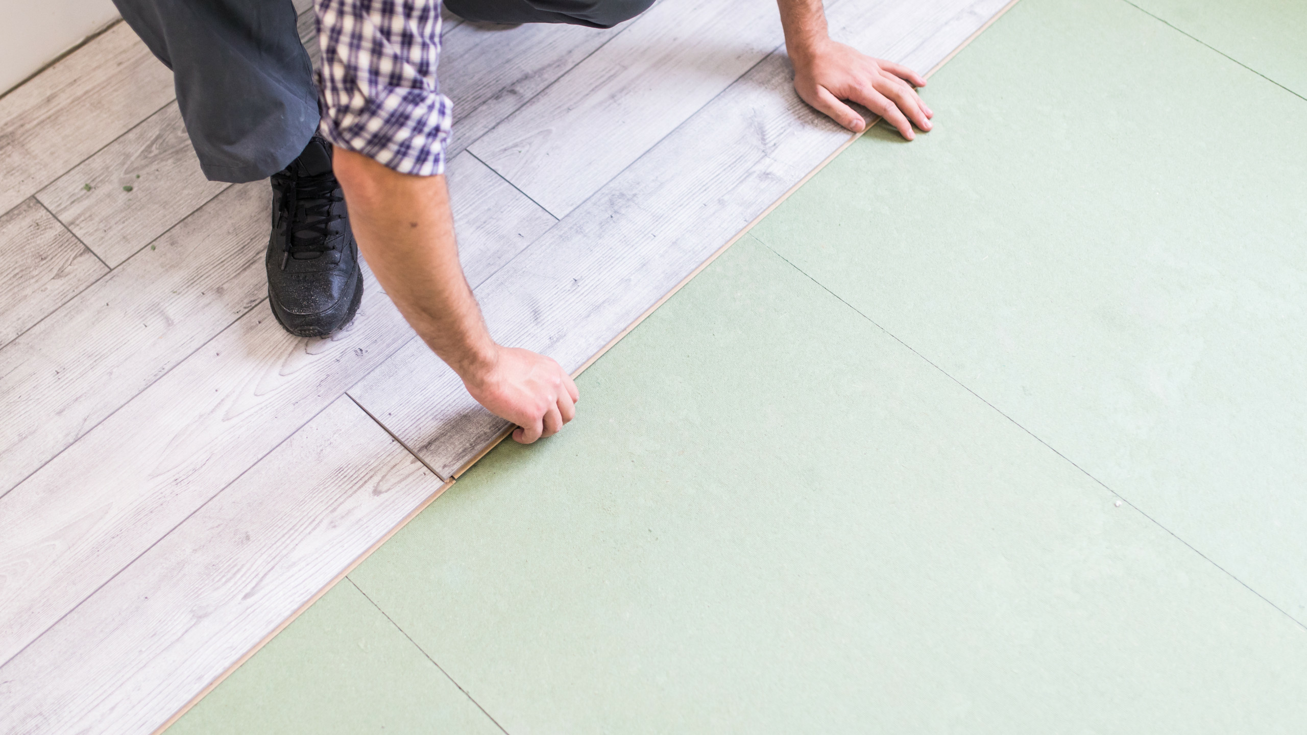 worker-processing-floor-with-bright-laminated-flooring-boards